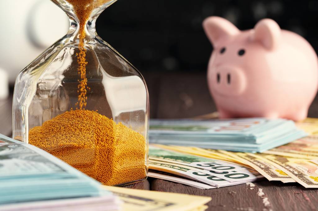 Time and money business concept. Sandglass and money