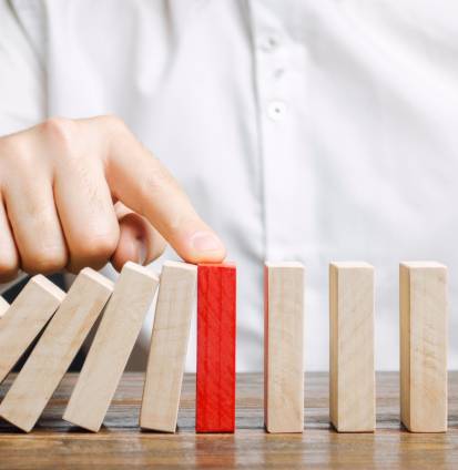 Businessman stops domino falling Businessman stops domino falling