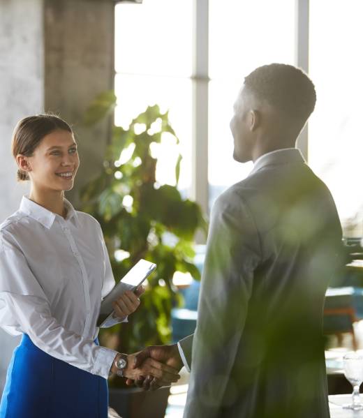 Pretty business lady shaking hand of business partner Pretty business lady shaking hand of business partner